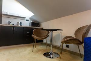 a kitchen with two chairs and a table in a room at Apart Hotel GOLDEN apartments in Košice