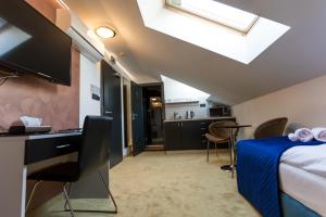 a room with a bed and a desk and a kitchen at Apart Hotel GOLDEN apartments in Košice