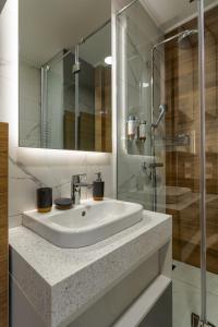 a bathroom with a sink and a glass shower at Golden Pine, a private apartment in five star hotel in Zlatibor