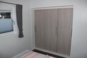 Mein-Mosel-Chalet-Haus-Birke في كوبلنز: غرفة نوم مع خزانة خشبية ونافذة