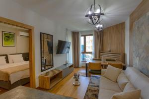 a hotel room with a bed and a living room at Golden Pine, a private apartment in five star hotel in Zlatibor