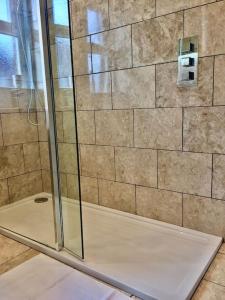a shower with a glass door in a bathroom at Kelvinside, Seahouses, 2 minute walk into village in Seahouses