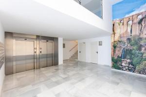 a hallway with elevators and a painting on the wall at Fabuloso Apartamento nuevo con Parking y Piscina in Málaga