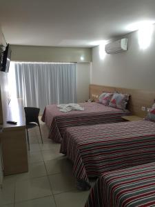 Itumbiara Palace Hotel tesisinde bir odada yatak veya yataklar
