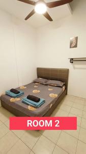 Taman Tunku Miri Budget Homestay في ميري: غرفة نوم مع سرير ومروحة سقف