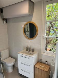 a bathroom with a sink and a toilet and a mirror at Paris : charmant 2 pièces au calme in Paris