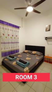 a bedroom with a bed with a ceiling fan at Taman Tunku Miri Budget Homestay in Miri