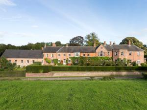 ein großes Haus mit grünem Rasen davor in der Unterkunft Lady Pond Retreat in Ashbourne