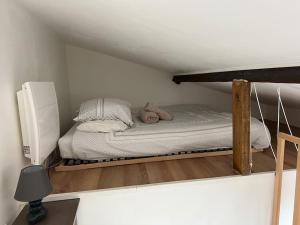 un letto con due orsacchiotti sopra in una stanza di Paris : charmant 2 pièces au calme a Parigi