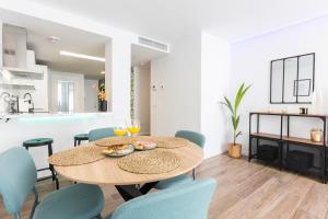 una sala da pranzo e una cucina con tavolo e sedie di Fabuloso Apartamento nuevo con Parking y Piscina a Málaga