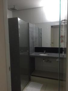 ein Bad mit einem Waschbecken und einer Glasdusche in der Unterkunft Itumbiara Palace Hotel in Itumbiara