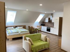 ein Wohnzimmer mit einem Sofa und einem Bett sowie eine Küche in der Unterkunft Hofbauer-Hof in Rastenfeld