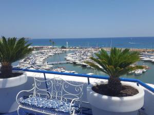 a balcony with a bench and a marina with boats at Apartamento Ines, Dehesa de Campoamor,900m from the sea , swimming pool & tennis court in Dehesa de Campoamor