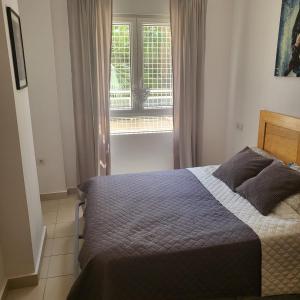 een slaapkamer met een bed voor een raam bij Apartamento Ines, Dehesa de Campoamor,900m from the sea , swimming pool & tennis court in Campoamor