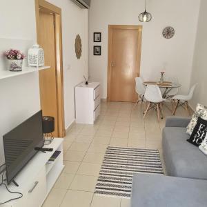 a living room with a couch and a table at Apartamento Ines, Dehesa de Campoamor,900m from the sea , swimming pool & tennis court in Dehesa de Campoamor