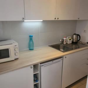 a kitchen counter with a microwave and a sink at Apartamento Ines, Dehesa de Campoamor,900m from the sea , swimming pool & tennis court in Campoamor