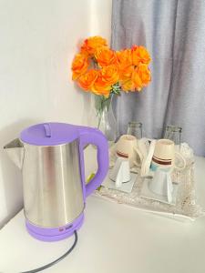 a purple and white blender on a counter with orange flowers at Best Rooms- Quarto 2 Plateau in Praia