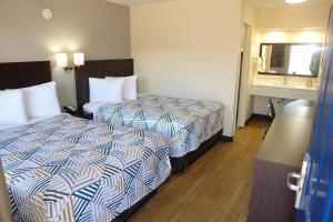um quarto de hotel com duas camas e um lavatório em Motel 6 Hattiesburg, MS em Hattiesburg