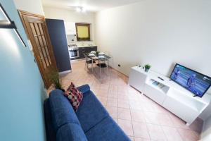 ein Wohnzimmer mit einem blauen Sofa und einem TV in der Unterkunft Centro di Aosta - Bilocale grazioso e silenzioso in Aosta