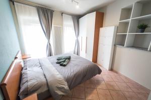 ein Schlafzimmer mit einem Bett und einem großen Fenster in der Unterkunft Centro di Aosta - Bilocale grazioso e silenzioso in Aosta