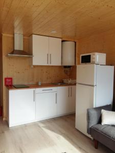 a kitchen with white cabinets and a white refrigerator at Villas do Rosal in Boa Vista de Cima