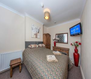Un pat sau paturi într-o cameră la Riverside Hotel