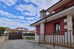 a red and white house with a balcony at Vivienda Vacacional El Remanso de Colombres in Colombres