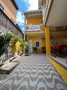 a courtyard of a building with a yellow building at Pousada Recanto da Ana Alice in Abraão