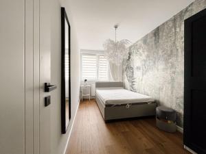 a bedroom with a bed and a wall at Apartament Kętrzyn in Kętrzyn