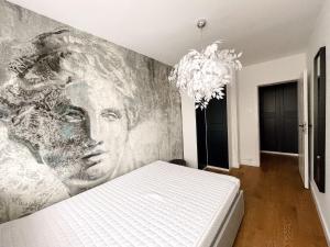 a bedroom with a painting of a woman on the wall at Apartament Kętrzyn in Kętrzyn