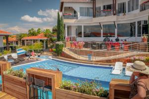 a woman standing next to a swimming pool at a resort at Hotel Mansión Barichara in Barichara