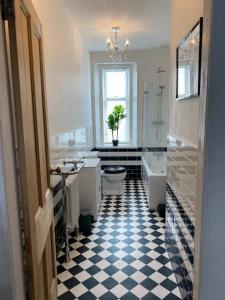 a bathroom with a black and white checkered floor at Seaclusion in Saint Monance