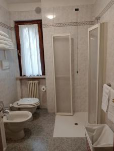 uma casa de banho com um chuveiro, um WC e um lavatório. em La casa di Sabrina em Verona