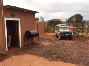 a jeep parked in front of a house with a building at Sonofjohnhomestay in Karatu