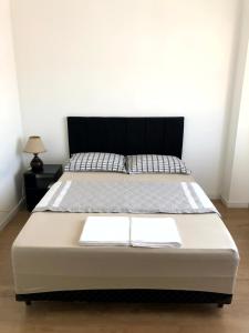 łóżko z dwoma białymi ręcznikami w pokoju w obiekcie Apto no centro da cidade mais alemã do Brasil w mieście Pomerode