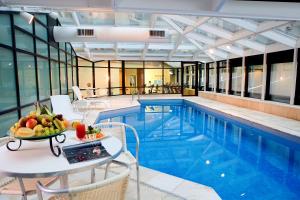 a pool with a table with a bowl of fruit on it at Hotel Bourbon Ibirapuera Suite 5 estrelas Moema in São Paulo