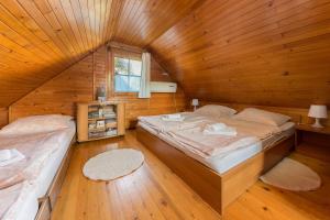 a bedroom with two beds in a wooden cabin at Brunarica Primas Čatež in Brežice