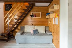 a couch in a living room with a staircase at Brunarica Primas Čatež in Brežice