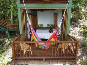 - une terrasse couverte avec un hamac et des chaises dans une maison dans l'établissement Casa Galú - Capurganá, à Capurganá