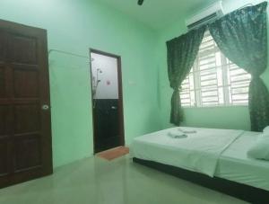 a bedroom with a bed and a window and a door at Seri Guesthouse Dungun in Kampong Sura Masjid