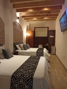 Hotel Del Valle في تيكوزاوتلا: غرفة فندقية بسريرين ومرآة