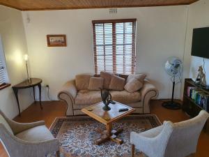 a living room with a couch and a table and chairs at Aurora Bushbaby 1 in Centurion