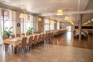 - une salle à manger avec des tables, des chaises et des fenêtres dans l'établissement Hotel Pod Szyszkami, à Koźmin