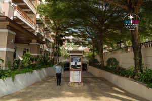 Um homem está numa cabine telefónica. em Patong Coco Apartment em Patong Beach