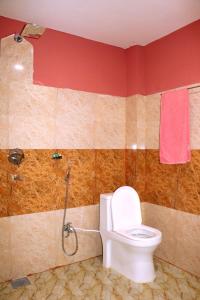 y baño con aseo y ducha. en Hotel National Park Sauraha- Homely Stay and Peaceful Location, en Sauraha