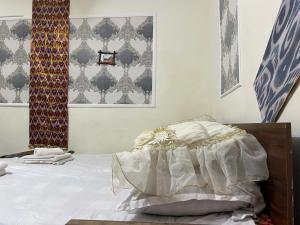 a bedroom with a bed with white sheets and patterns at SAMARKAND AMIRA in Samarkand