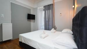 a bedroom with a white bed with towels on it at Athens City Themis 14 in Athens