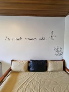 a bedroom with a bed with a quote on the wall at Village São Jorge - Guest Apartment in Sao Jorge