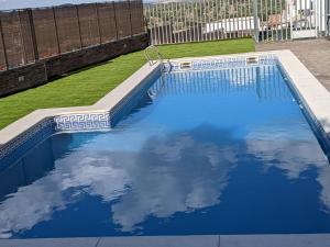 una piscina azul con reflejo del cielo en El Barro Colorao, en Segura de León