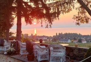 un gruppo di sedie di vimini seduti su un patio con un tramonto di Maison Bagatell Badacsony a Badacsonytomaj